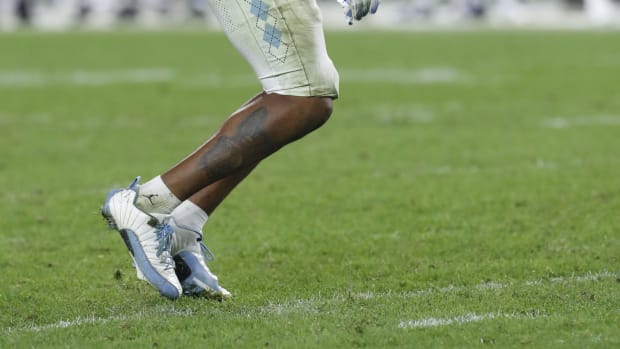 Detailed look at North Carolina Tar Heels linebacker Cedric Gray's white and blue Air Jordan cleats.